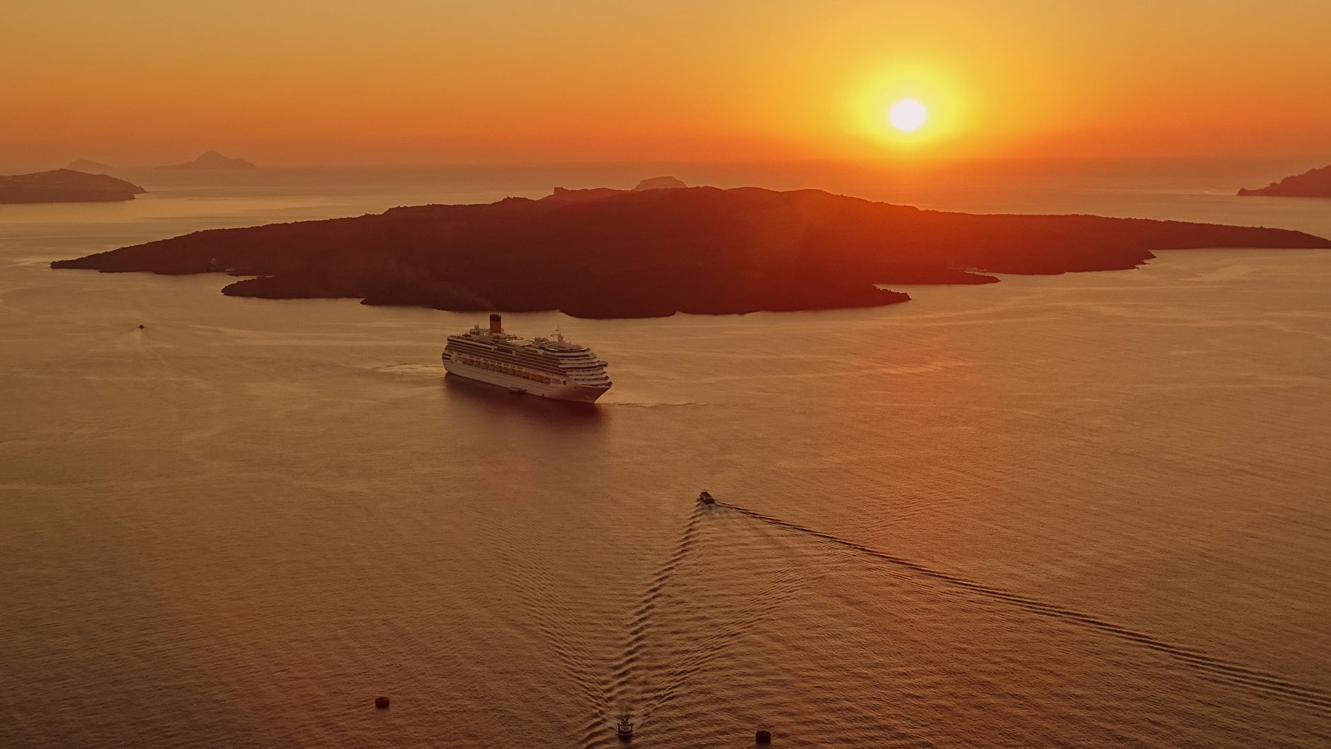 A ship's silhouette on the open ocean at dusk