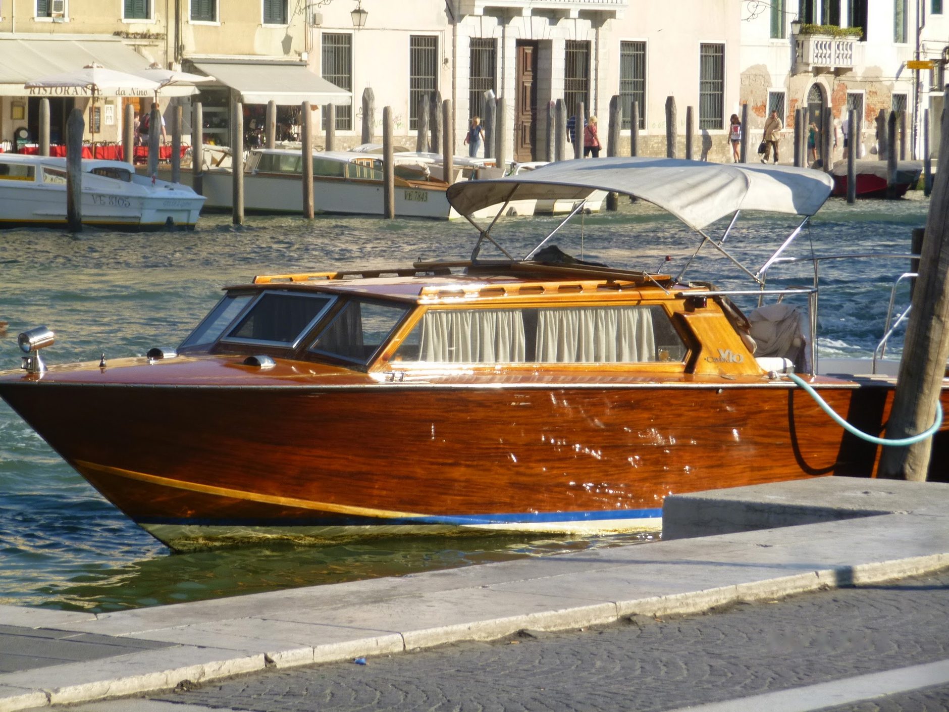 A polished wooden water taxi waiting in Venice